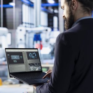 photovoltaics factory technician optimizing production flow using laptop