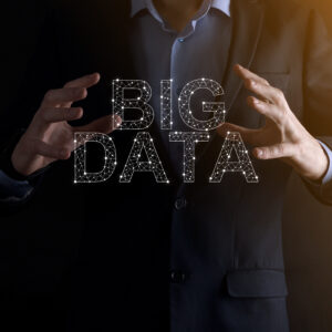 businessman in a suit on a dark background holds the inscription big data. storage network online server concept.social network or business analytics representation