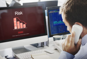 someone at a computer looking at a graph labeled "Risk" and it is declining