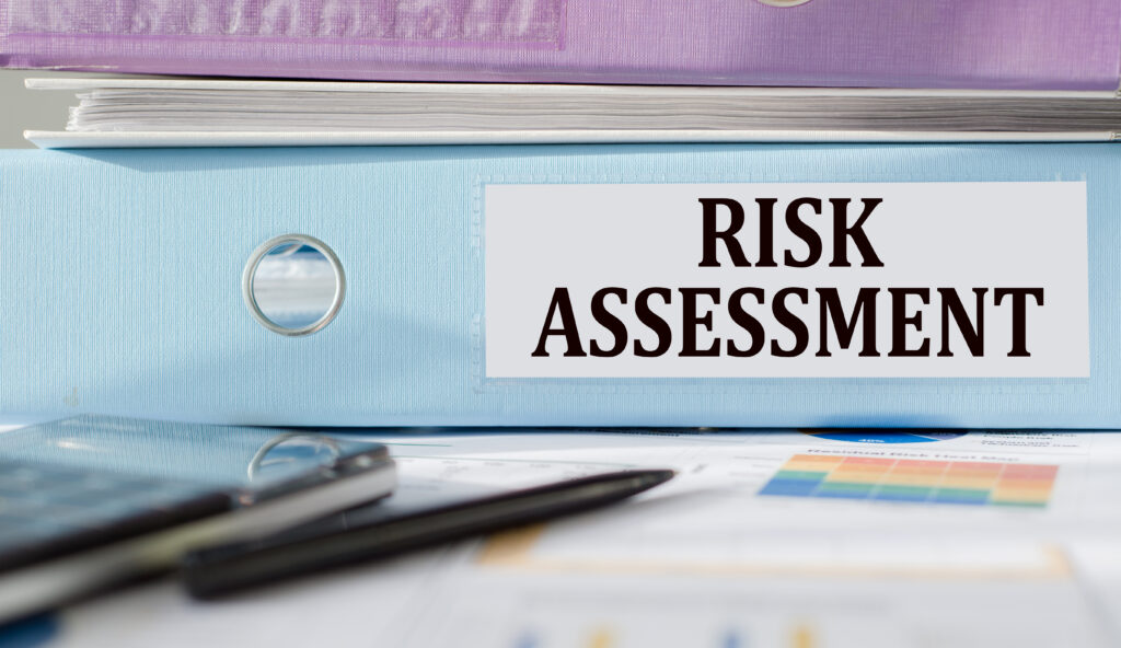 risk assessment text written on folder with documents and calculator.