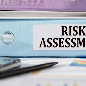 risk assessment text written on folder with documents and calculator.