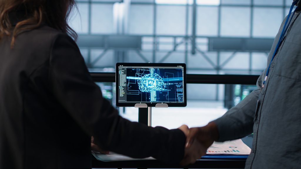 manager meeting with client in data center to review files, doing handshake